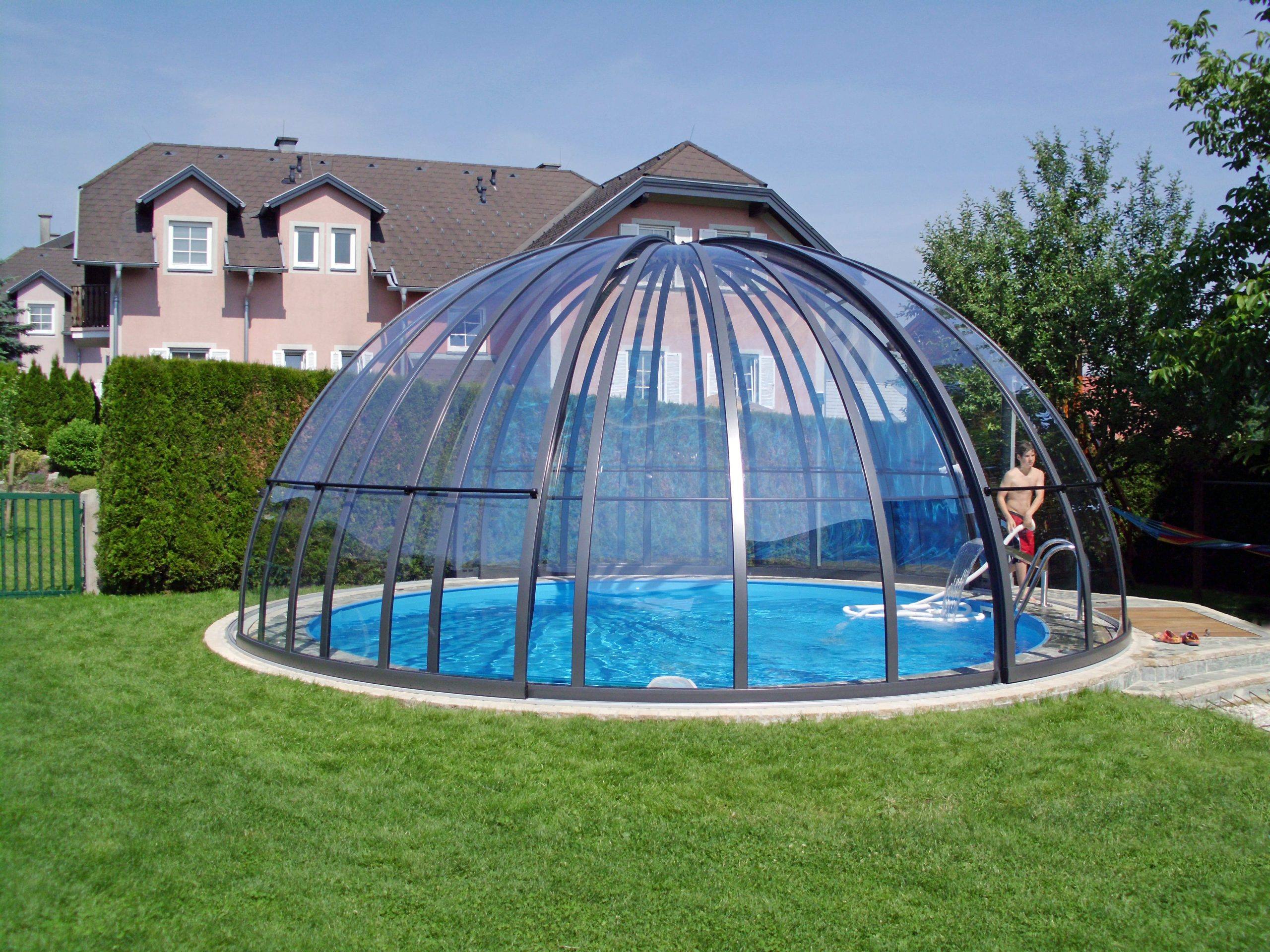 Piscine couverte dôme transparent jardin maison.