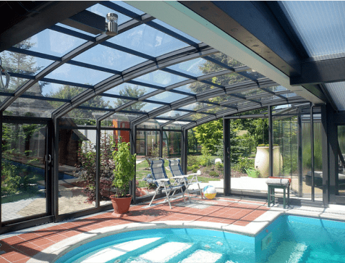 Véranda moderne avec piscine intérieure et jardin.